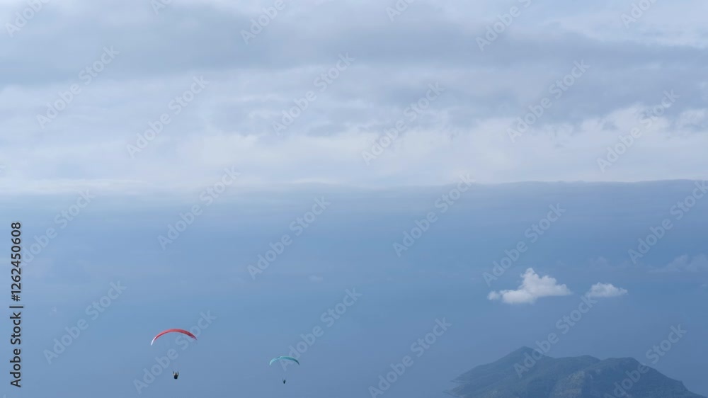 two paragliders soaring in the cloudy sky over Oludeniz, turkey , stunning aerial view two paragliders soaring in the cloudy sky over Oludeniz, turkey , stunning aerial view