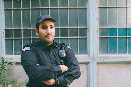 Security guard standing vigilantly in urban environment portrait photography middle eastern male emphasizing duty and responsibility photo