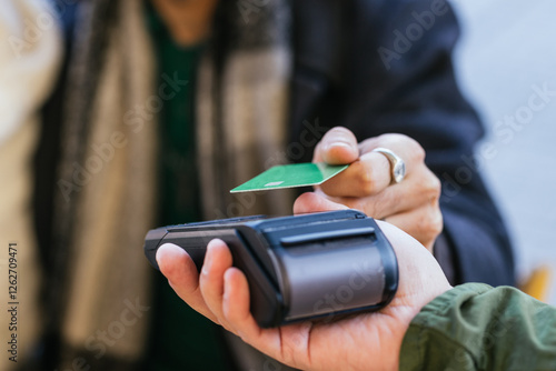Customer paying with contactless credit card at pos terminal
