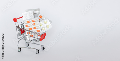 Side view of a mini shopping cart full of pills. The concept of online shopping medicine on white background. Online Pharmacy. health insurance. Banner. Space for text