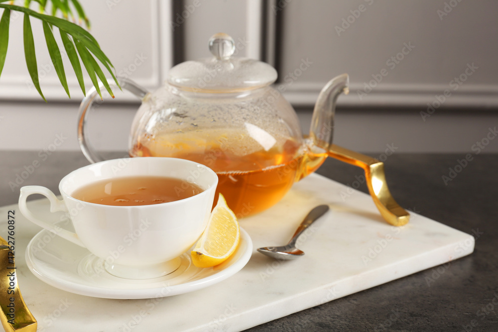 Refreshing green tea, spoon and slice of lemon on dark textured table Refreshing green tea, spoon and slice of lemon on dark textured table