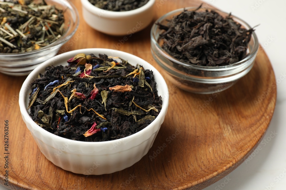 Different dry tea leaves in bowls on white table, closeup Different dry tea leaves in bowls on white table, closeup