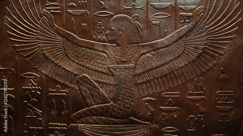 A detailed relief of the ancient Egyptian goddess Isis, depicted with outstretched wings. Surrounded by hieroglyphic inscriptions, this artwork symbolizes protection, wisdom, and divine guidance.