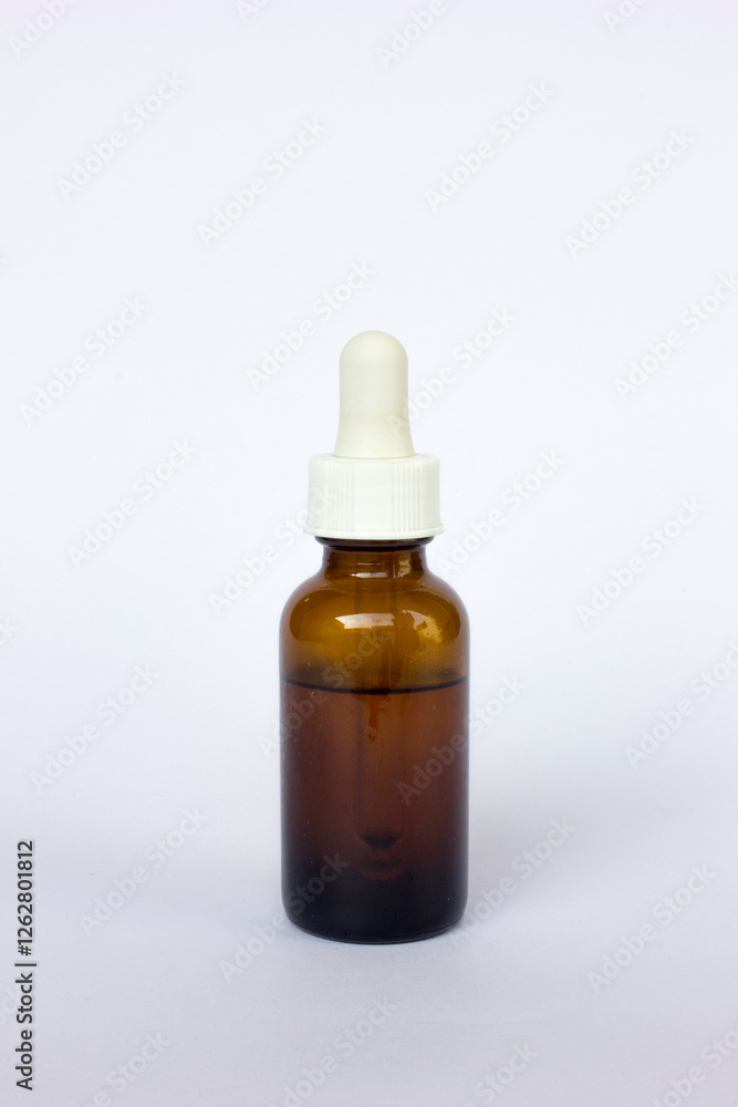 Brown glass bottle with pipette on isolated white background. This bottle contains the liquid that will be used for research. Brown glass bottle with pipette on isolated white background. This bottle contains the liquid that will be used for research.