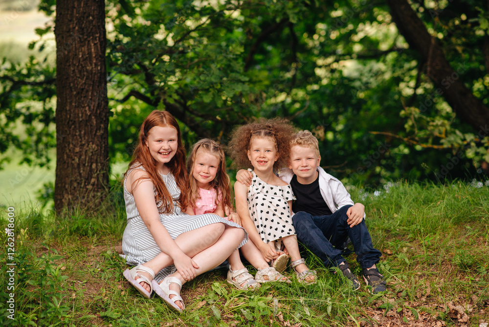 Four children, sisters and brother, spending time together in nature, smiling, playing, and enjoying the outdoors Four children, sisters and brother, spending time together in nature, smiling, playing, and enjoying the outdoors