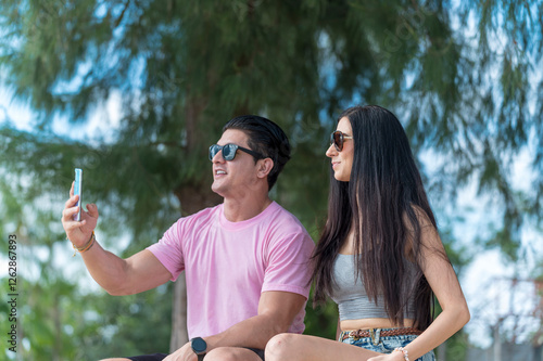 Obraz na płótnie Young Lover Man take vdo call with woman they are very happy and smile in outdoor background enjoy at the beach - summer vacation on sea beach concept w salonie