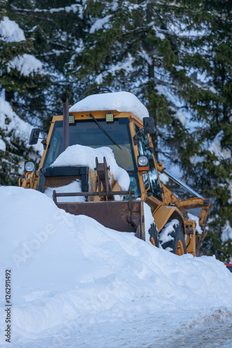 snowplow covered with snow in the mountains, cleaning the roads in winter. Snow removal equipment in winter conditions