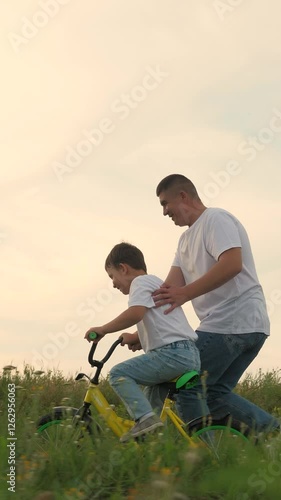 man father teaches boy son ride bike, schoolboy boy playing happily dad park, father running after bike child green meadow, happy family outdoors, children dream, adrenaline fast cycling, childhood