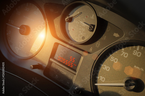 Close-up of car dashboard in sunset light with odometer reading 