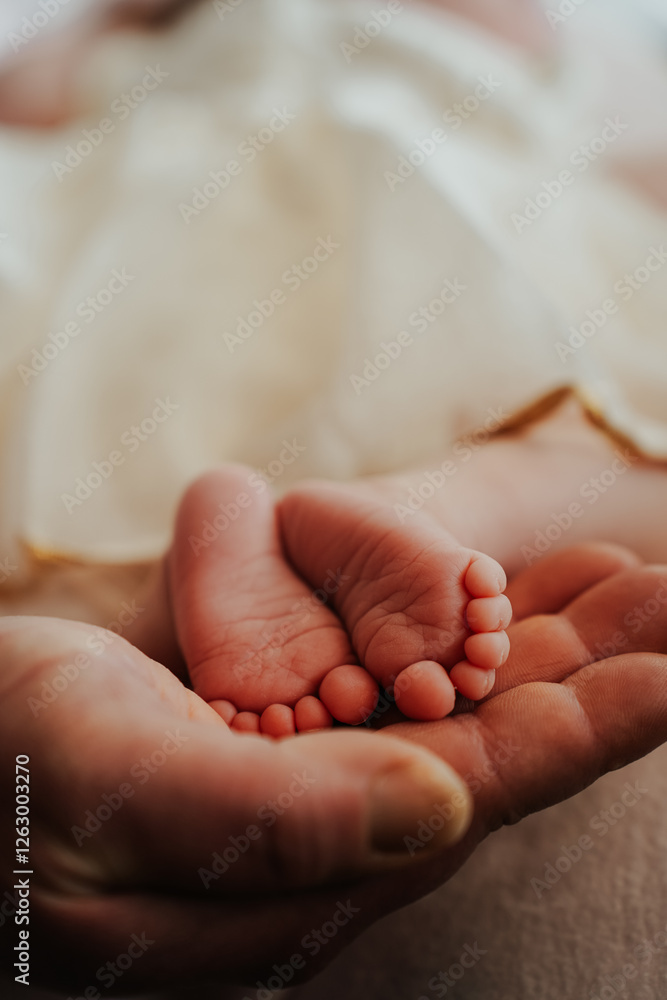 A father's gentle hands cradle his newborn's little toes. A father's gentle hands cradle his newborn's little toes.
