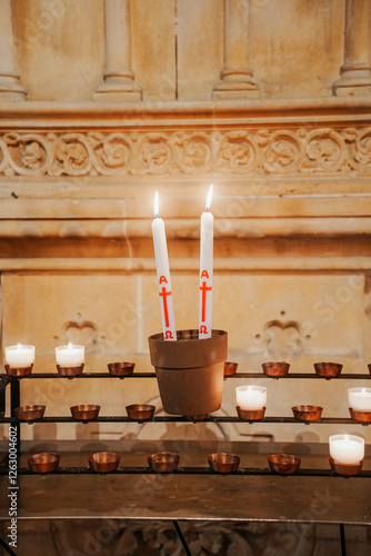 lit catholic baptismal candle, creating a warm and spiritual atmosphere in church. Perfect for religious events, traditins, and Christian celebrations.