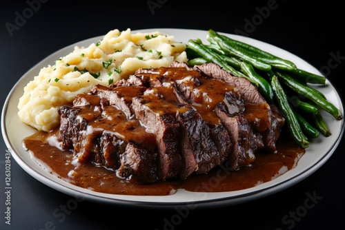 Delicious roast beef dish with mashed potatoes and gravy with green beans.