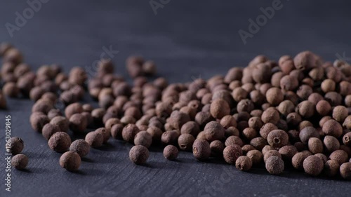 Pile allspice or Jamaican pepper on a black stone table. Heap allspice or Jamaican pepper on a black kitchen table.