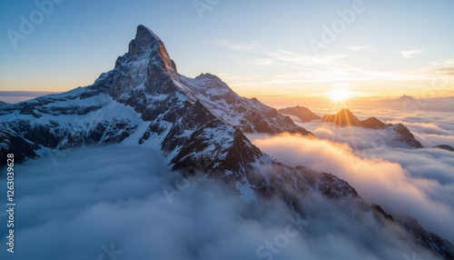 Winter sunset and sunrise over snowy mountain peaks with clouds and a scenic alpine view