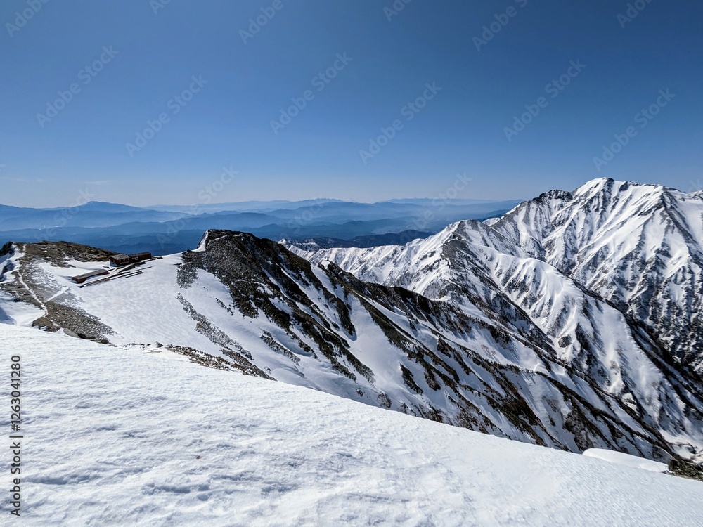Karamatsu Chojo Hut closed for the winter season and the ridgeline to Mt. Goryu seen from snow-covered Mt. Karamatsu in Hakuba, Nagano prefecture Japan in April. Karamatsu Chojo Hut closed for the winter season and the ridgeline to Mt. Goryu seen from snow-covered Mt. Karamatsu in Hakuba, Nagano prefecture Japan in April.