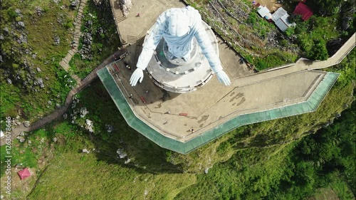 aerial footage of the famous jesus statue in toraja maelo in the morning with a bird's eye view and tilt up photo