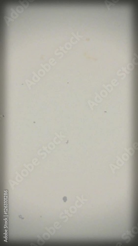 Vintage white film background with vignette in vertical format with copy space. Dusty and grainy feel with scratches and noise. 4K motion graphics. Ideal for smartphone vertical video projects.