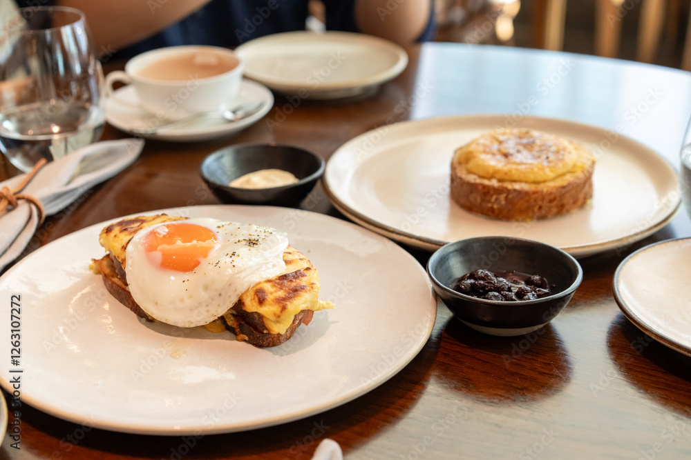 A fried sunny-side-up egg topped with black pepper sits beautifully on melted cheese toast, served on a white plate. Perfect for promoting breakfast menus, cafes, or food blogs. A fried sunny-side-up egg topped with black pepper sits beautifully on melted cheese toast, served on a white plate. Perfect for promoting breakfast menus, cafes, or food blogs.