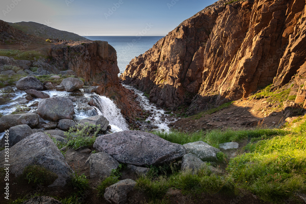 Battery waterfall on the coast of the Barents Sea near the village of Teriberka in the evening on a polar day Battery waterfall on the coast of the Barents Sea near the village of Teriberka in the evening on a polar day