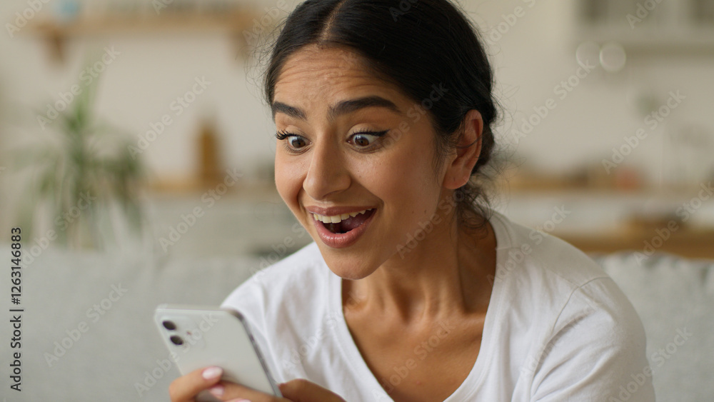 Happy smiling excited joyful amazed surprised wonder Hindu woman Indian girl Arabian female at home reading amazing good news online offer internet success win mobile phone victory winning smartphone Happy smiling excited joyful amazed surprised wonder Hindu woman Indian girl Arabian female at home reading amazing good news online offer internet success win mobile phone victory winning smartphone
