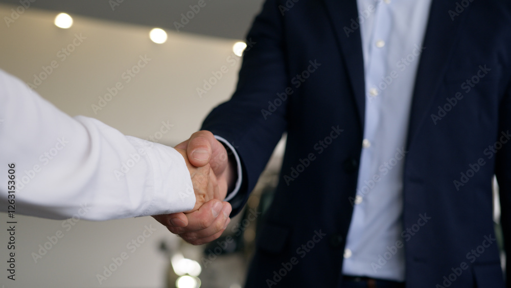 Fototapeta premium Two unrecognizable people in car salon hands close up Caucasian male client buyer man guy new automobile buying test drive bank credit handshaking woman dealer saleswoman female girl give key of auto