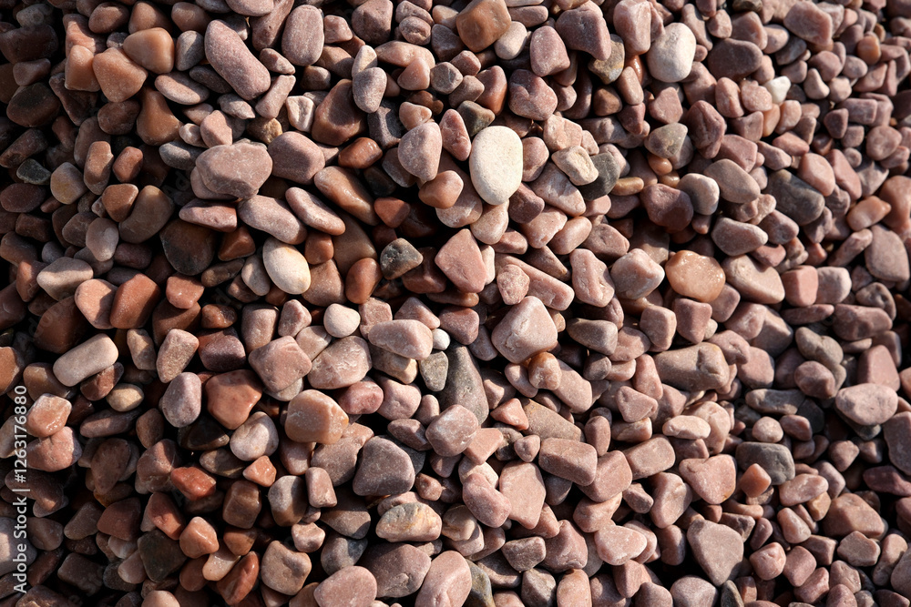 Varied textures of smooth pebbles in natural sunlight shining brightly Varied textures of smooth pebbles in natural sunlight shining brightly