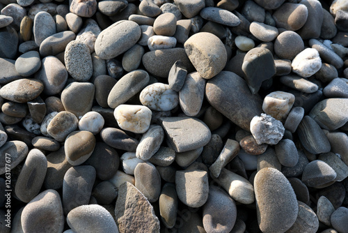 Nature's mosaic of smooth pebbles glistening in sunlight photo