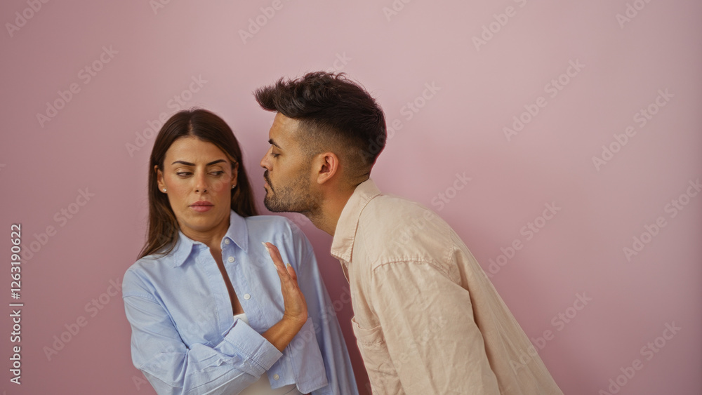 Woman rejecting kiss from man in awkward relationship moment over isolated pink background showcasing tension. Woman rejecting kiss from man in awkward relationship moment over isolated pink background showcasing tension.