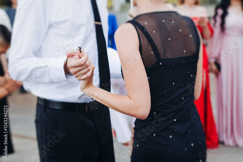 High school graduates dancing on prom, waltz and classical ball slow dance in dresses and suits on school graduation party, boys and girls ballroom dancers, couples dance quadrille and polonaise photo