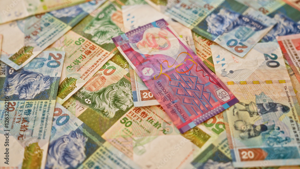 Hong kong dollar banknotes scattered on a flat surface showcasing colorful currency from hong kong in a close-up financial scene.