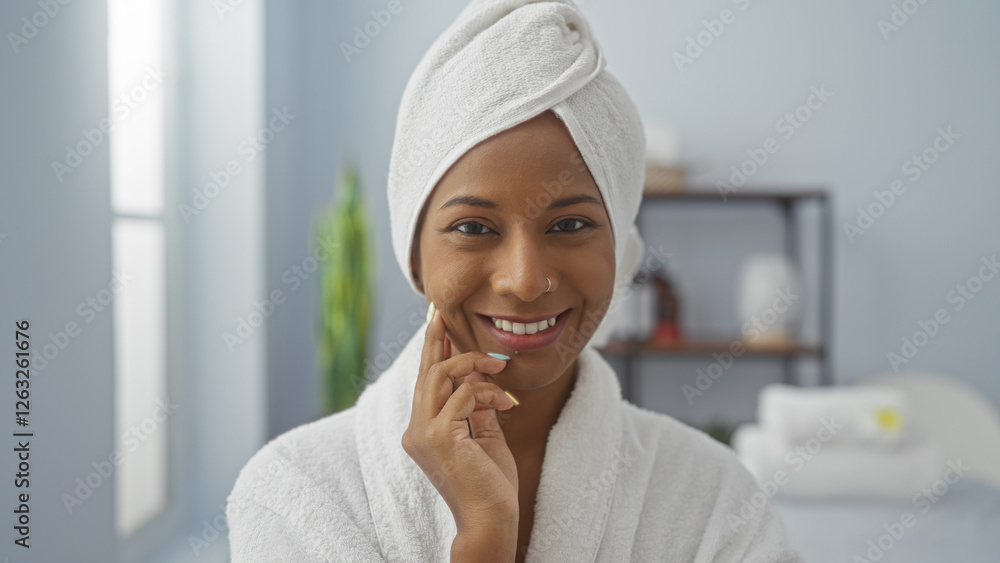 Woman smiling in spa wearing white towel turban and robe inside peaceful wellness center Woman smiling in spa wearing white towel turban and robe inside peaceful wellness center