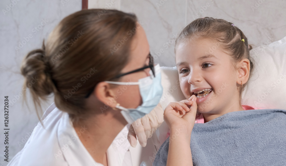 5 year old girl in pediatric dentistry office, the dentist is assisting her. 5 year old girl in pediatric dentistry office, the dentist is assisting her.