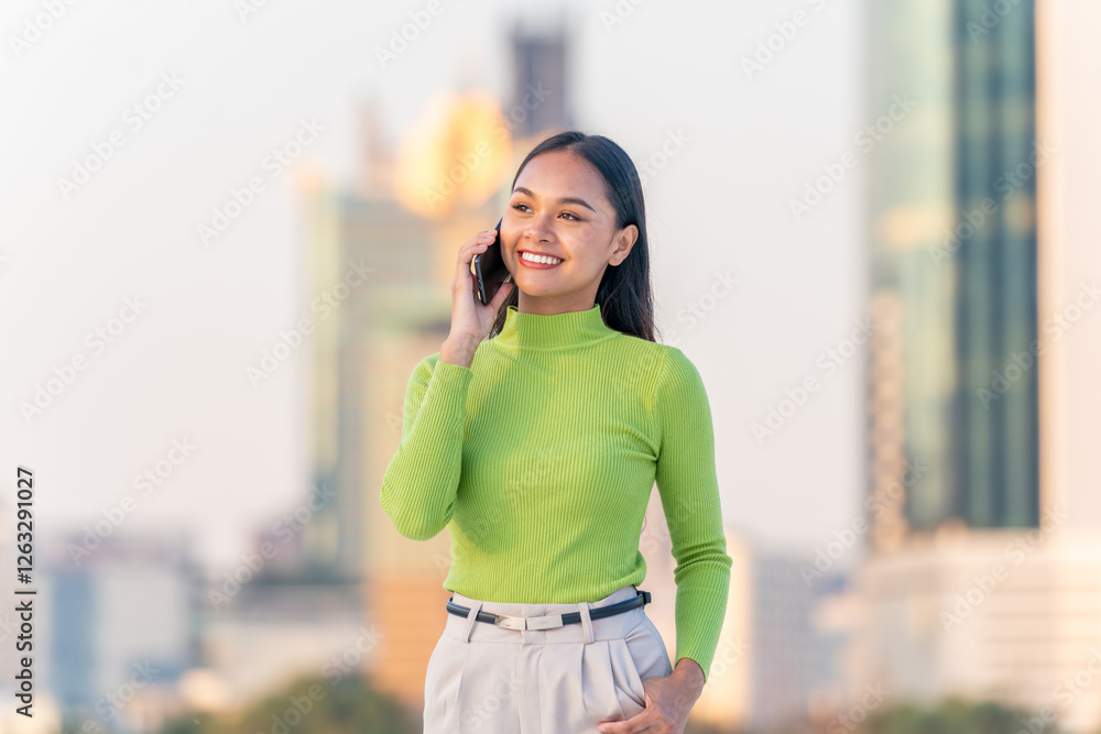Fototapeta premium Young Asian Woman Talking on Phone in Modern City Outdoors