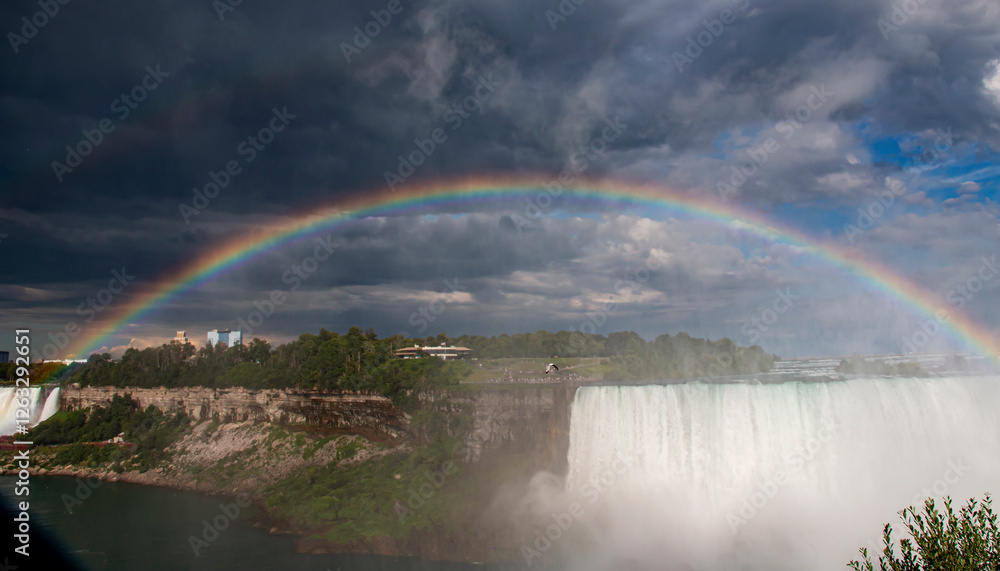 A Rainbow Arches Over Niagara Falls During an Overcast Day in Summer A Rainbow Arches Over Niagara Falls During an Overcast Day in Summer