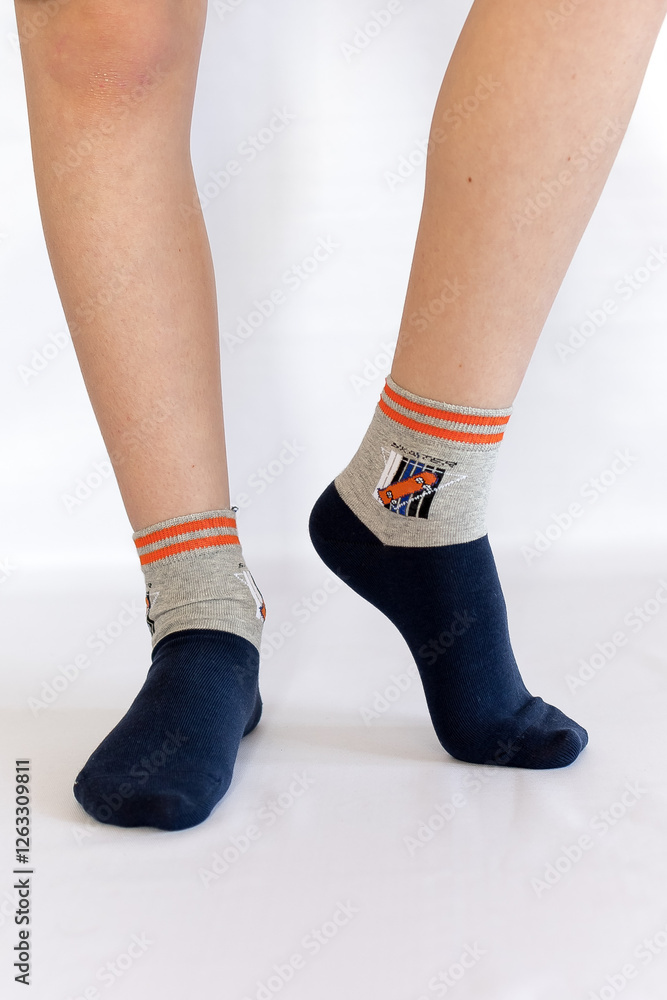 Men's feet in black grey sneakers and black socks on a white background Men's feet in black grey sneakers and black socks on a white background