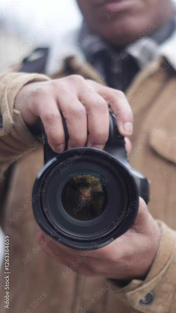 Photographer holding digital camera, adjusting settings Photographer holding digital camera, adjusting settings