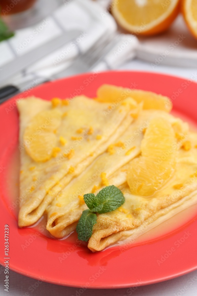 Plate with tasty crepes Suzette on white table, closeup Plate with tasty crepes Suzette on white table, closeup