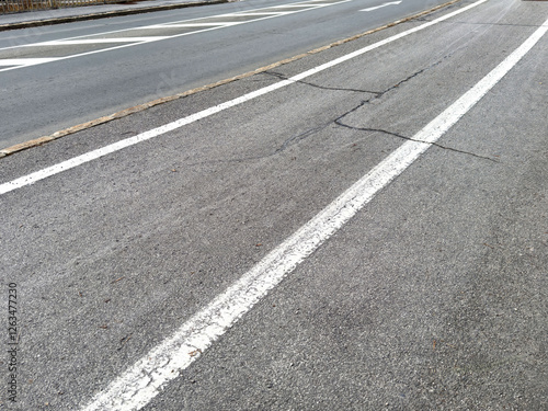 Wallpaper Mural Urban road with cracks and faded white lines on asphalt surface Torontodigital.ca