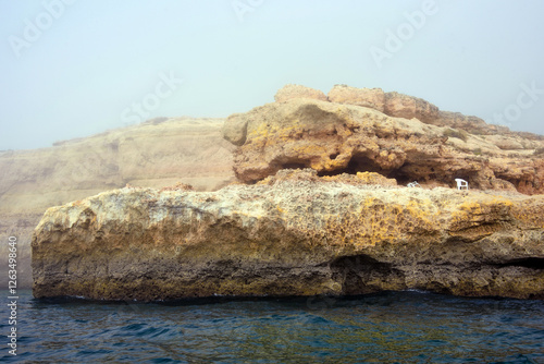 foggy landscape, the Algarve rock formation  is a unique and amazing natural wonder located in the coastal town of Porches, Portuga photo