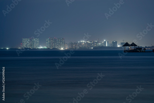 Obraz na płótnie Unique landscape about the Maldives. Capital city, Malé is on the background. Illuminated small rest place with bed on the foreground. w salonie
