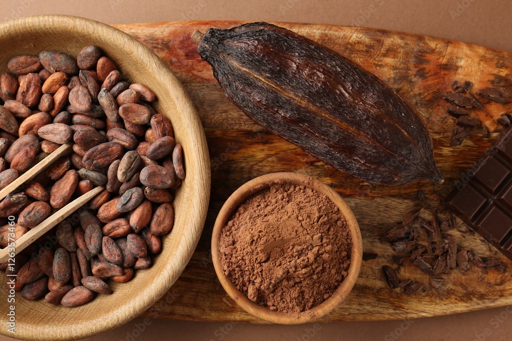 Cocoa pod, beans and powder on brown background, top view Cocoa pod, beans and powder on brown background, top view