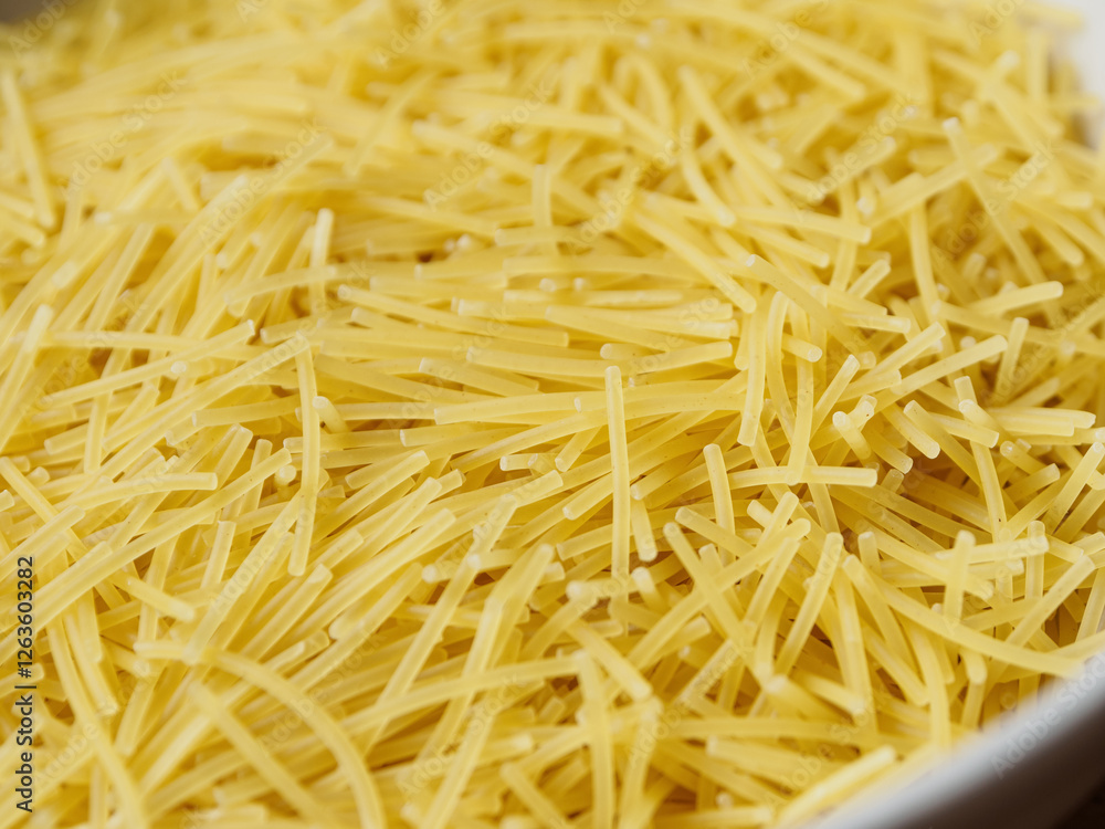 Close-up of small, thin vermicelli filini pasta. Delicate strands create a fine, textured food background. Close-up of small, thin vermicelli filini pasta. Delicate strands create a fine, textured food background.