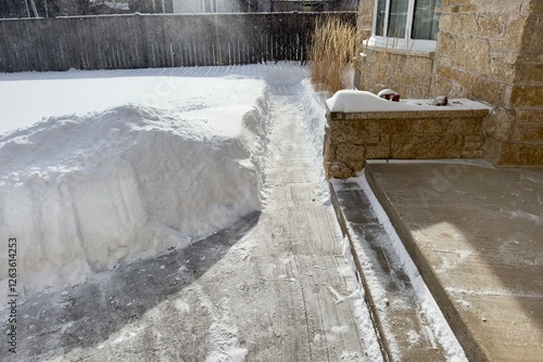 Foto A snow-covered yard and a cleared path around the house
