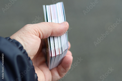 A hand holding a pack of trading cards