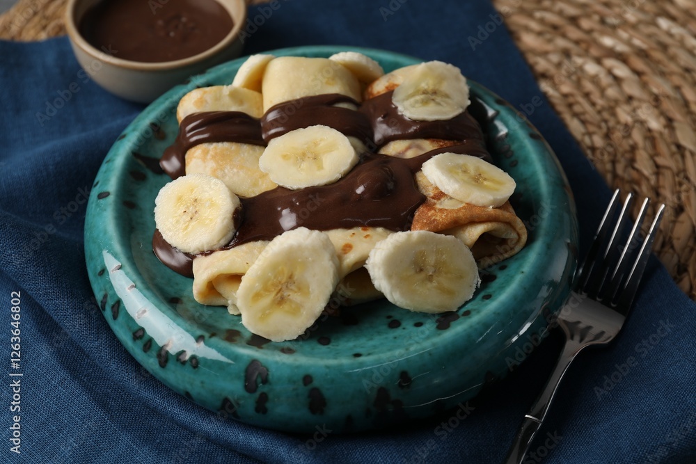 Delicious crepes with banana and chocolate paste on table, closeup Delicious crepes with banana and chocolate paste on table, closeup