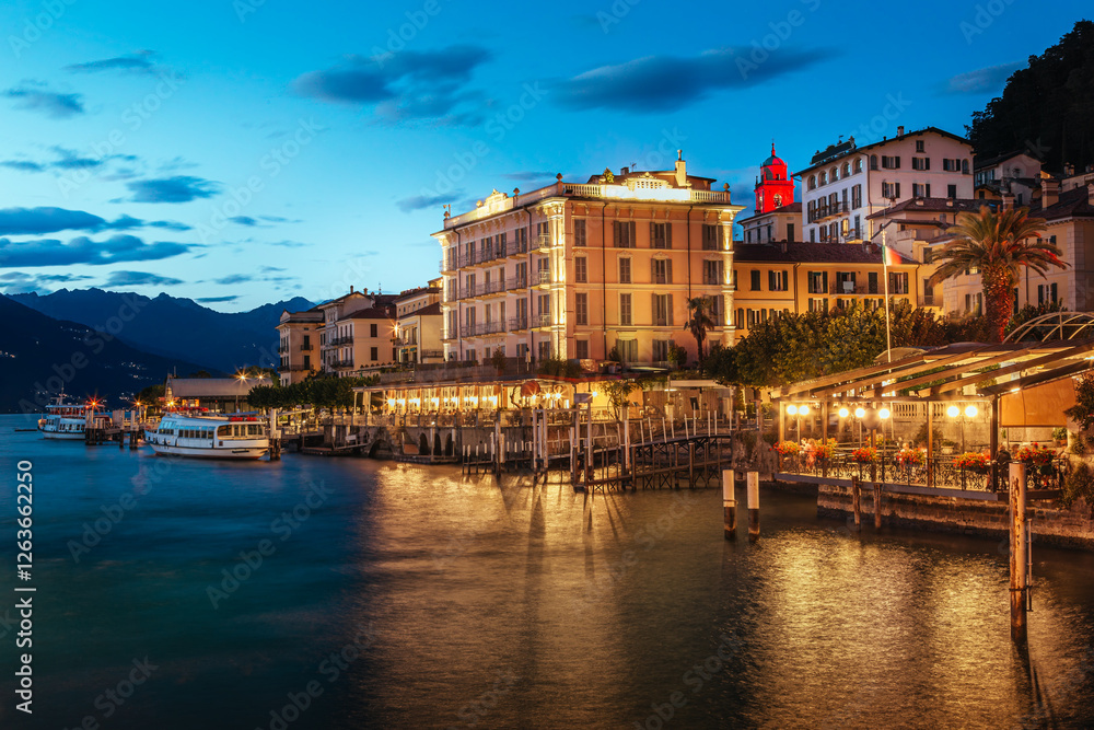 Scenic view of Bellagio at dusk with illuminated buildings along Lungolario Guglielmo Marconi. Calm waters of Lake Como reflect the vibrant evening lights, creating a serene atmosphere Scenic view of Bellagio at dusk with illuminated buildings along Lungolario Guglielmo Marconi. Calm waters of Lake Como reflect the vibrant evening lights, creating a serene atmosphere