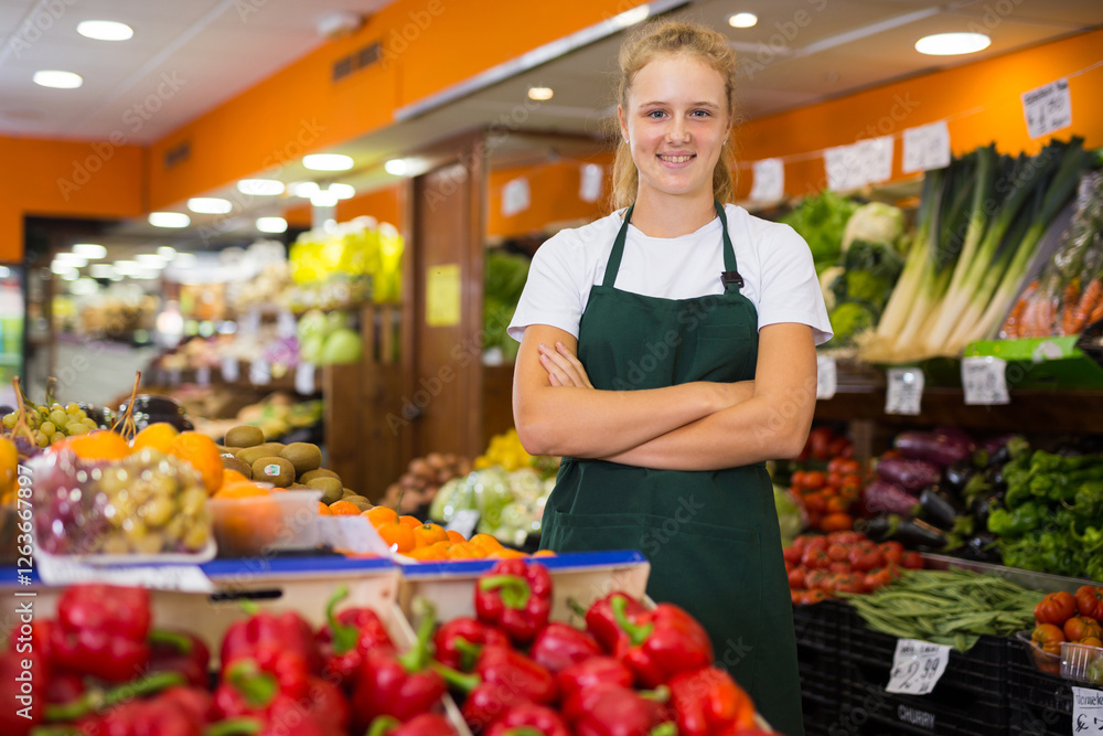 Portrait of young smiling woman worker seller in a vegetable section supermarket standing at work place Portrait of young smiling woman worker seller in a vegetable section supermarket standing at work place