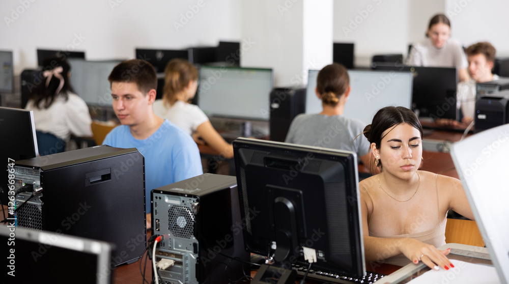 Fototapeta premium Interested girl student copying notes on copier while studying in college computer class