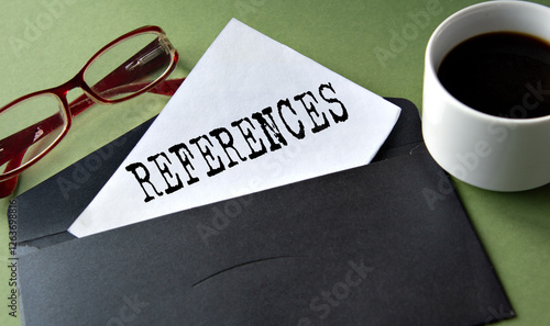 REFERENCES - words on a white sheet of paper on a background of a black convers and a cup of coffee photo