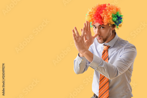Valokuva Businessman in clown wig grimacing on yellow background